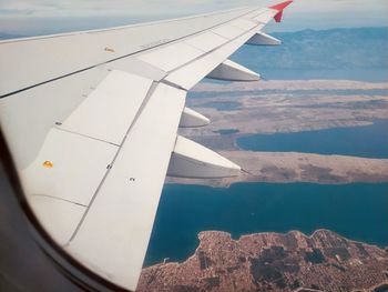 Airplane flying over sea against sky