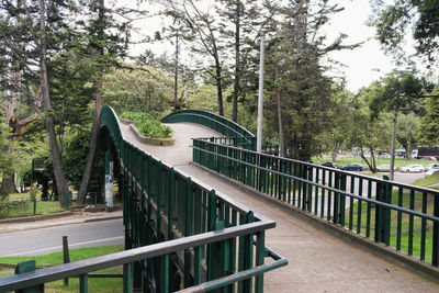 Footbridge in park against sky