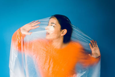 Woman standing against blue background