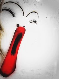 Close-up of red object over white background