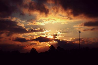 Silhouette of trees against dramatic sky