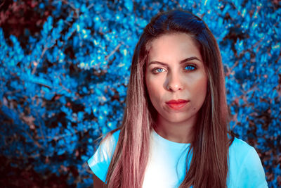 Portrait of beautiful young woman with blue eyes standing outdoors