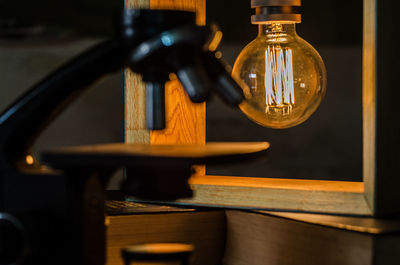 Close-up of illuminated light bulb on table