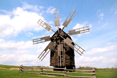 Traditional windmill on field against sky