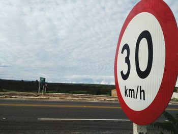 Close-up of road sign against sky