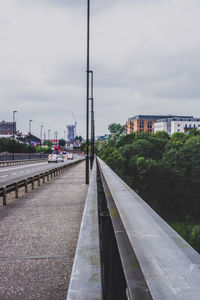 Road by canal against sky in city
