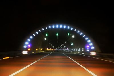 Illuminated tunnel at night