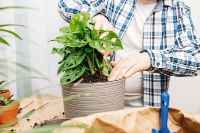 Midsection of woman holding potted plant