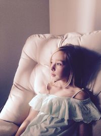 Portrait of cute girl lying on bed at home