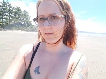 Portrait of woman wearing sunglasses on beach