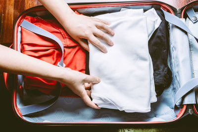 Cropped hands of person packing suitcase