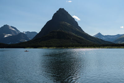 Scenic view of lake by mountains against sky