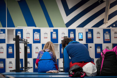 Rear view of people sitting in corridor