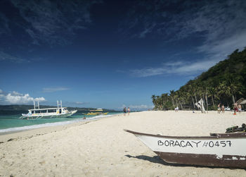 Sailboats moored on beach against sky