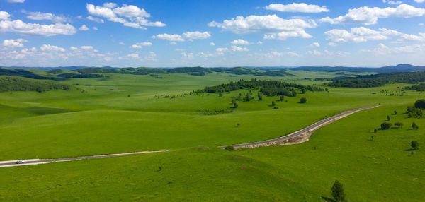 Scenic view of green landscape against sky