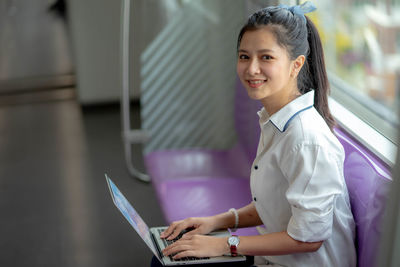 Portrait of smiling woman using mobile phone