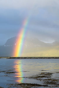 Scenic view of rainbow over sea against sky