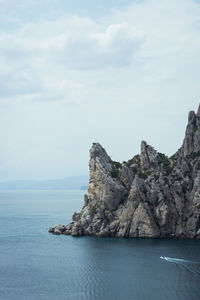 Rock formations by sea against sky