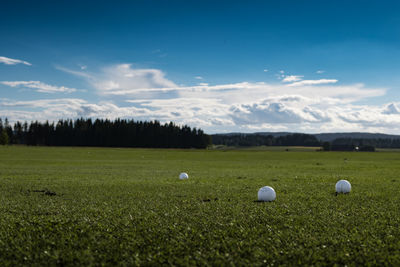 Scenic view of grassy field against cloudy sky