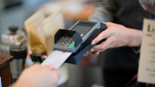 Customer insert credit card in payment machine to pay coffee drink at coffee shop, contactless