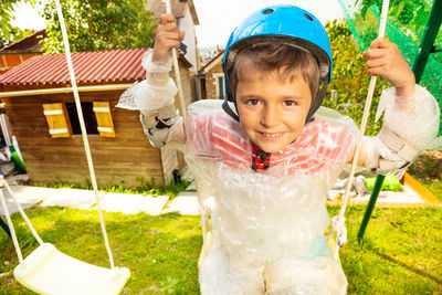 Portrait of boy standing on slide at playground