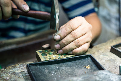 Cropped image of craftsperson working on table at workshop