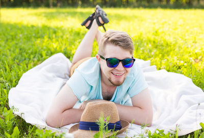 Portrait of smiling man lying down on field