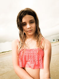Portrait of girl at beach against cloudy sky