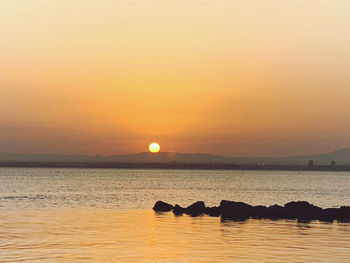 Scenic view of sea against orange sky