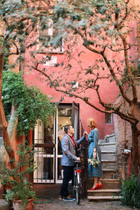 Side view of young couple standing against building