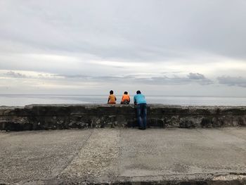 Rear view of father with sons against sea