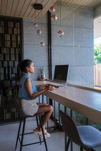 Woman using laptop at cafe