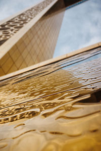 Close-up of metallic structure in sea against sky