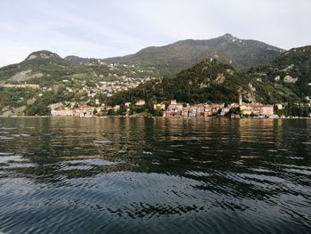 Scenic view of townscape by mountains against sky