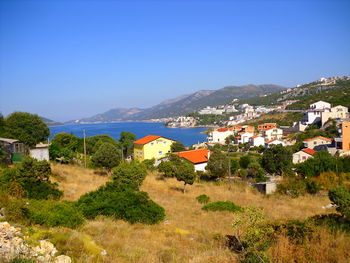 Houses in town against clear blue sky