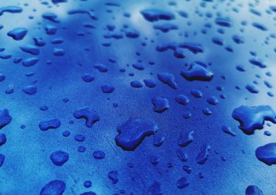 Full frame shot of raindrops on blue surface