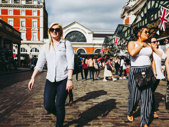 Full length portrait of young woman standing in city