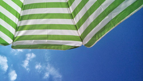 Low angle view of umbrella against blue sky