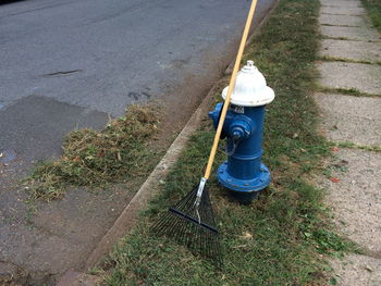 High angle view of broom on blue fire hydrant by road