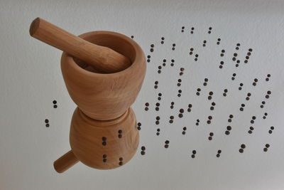 High angle view of wooden bowl and pepper on table