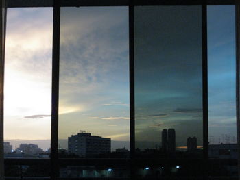 View of cityscape against cloudy sky