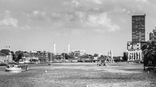 View of city buildings against cloudy sky