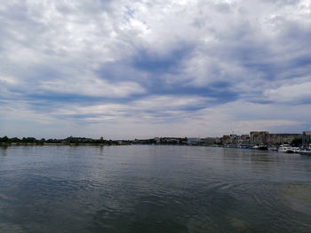 Scenic view of sea by buildings against sky