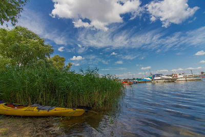 Boats moored in river against sky