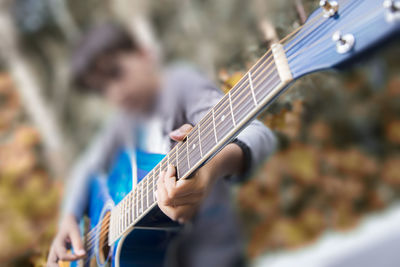Close-up of boy playing guitar