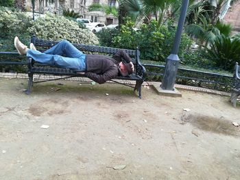 Man relaxing on seat against plants