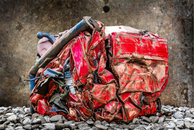 Close-up of crushed red car at junkyard