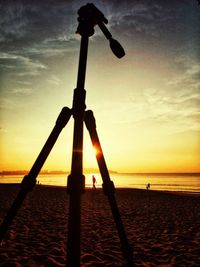 Silhouette people on beach against sky during sunset