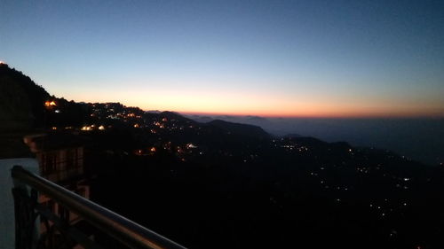 High angle view of illuminated cityscape against clear sky during sunset