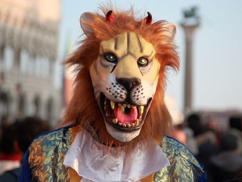 Close-up of person wearing mask against sky